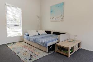 a bedroom with a bed and a coffee table at The Lake Guesthouse in Budgewoi