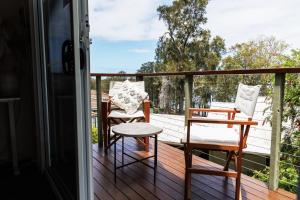 a porch with two chairs and a table on a deck at The Lake Guesthouse in Budgewoi