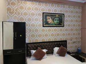 a bedroom with a bed and a picture on the wall at DS Residency Varanasi-Prime Location with Parking in Varanasi
