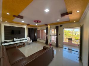 a large living room with a couch and a tv at Hotel Mahabaleshwar Mount View in Mahabaleshwar