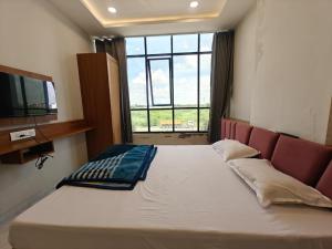 a large bed in a room with a large window at Hotel Avenue Gest House in Dabhoi +11 photos