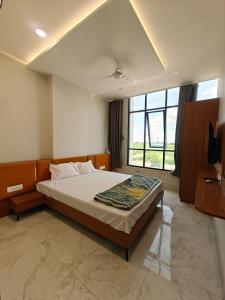 a bedroom with a large bed and a large window at Hotel Avenue Gest House in Dabhoi
