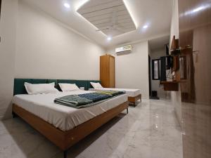 a bedroom with a large bed in a room at Hotel Avenue Gest House in Dabhoi