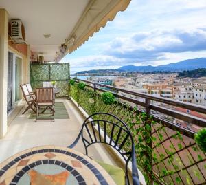 a balcony with chairs and a view of a city at Corfu SKYLINE RESIDENT 360 in Corfu