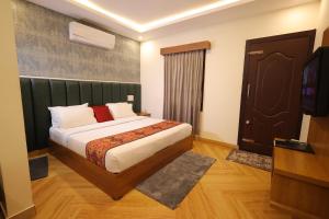 a bedroom with a bed and a television in it at Le Eden Premium Wayanad Pool Resort in Sultan Bathery