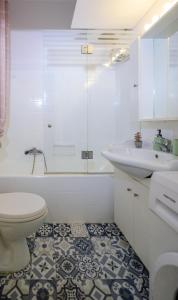 a white bathroom with a toilet and a sink at Corfu SKYLINE RESIDENT 360 in Corfu +27 photos