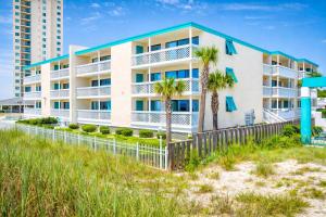 a white building with palm trees in front of it at Ocean Shores 301 in North Myrtle Beach