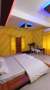a bedroom with two beds and a table and chairs at Greeny Homestay in Cochin