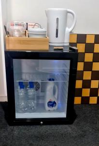a small black table with a refrigerator with water bottles at Private Ensuite Room in Rolleston
