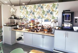 a kitchen with a counter top with a coffee shop at Atlantic Hôtel in Pau