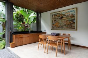 a dining room with a wooden table and chairs at JAPA Suites & Villas in Ubud