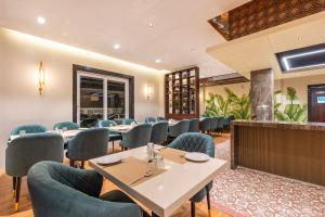 a restaurant with tables and chairs and a bar at Treebo Premium Pine Tree Courtyard in Chennai