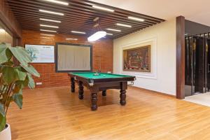 a room with a pool table and a screen at Treebo Premium Pine Tree Courtyard in Chennai +38 photos