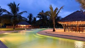 a resort swimming pool with a gazebo and palm trees at The Cove Pasikuda - Eco Retreat in Pasikuda