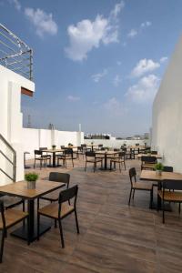a patio with tables and chairs on a roof at Hotel Golden Palace in Agra