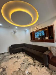 a living room with a couch and a large ceiling at Hotel Golden Palace in Agra