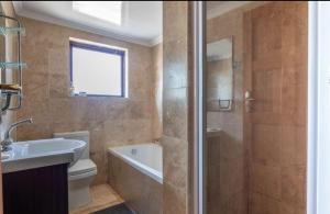 a bathroom with a shower and a sink and a toilet at 44SeagullMelkbosstrand in Melkbosstrand +23 photos
