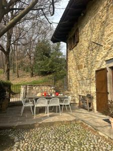 a patio with a table and chairs next to a stone building at La cantina dell'artista in Palazzago