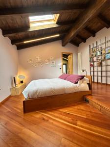 a bedroom with a large bed in a room with wooden floors at La cantina dell'artista in Palazzago