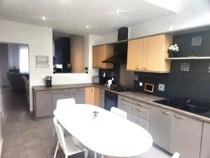 a kitchen with a white table and chairs in it at Welcome to our Mouscron cocoon in Marcinelle