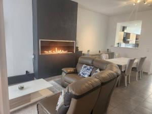 a living room with a couch and a fireplace at Welcome to our Mouscron cocoon in Marcinelle