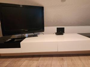 a white entertainment center with a computer monitor on it at Welcome to our Mouscron cocoon in Marcinelle +6 photos