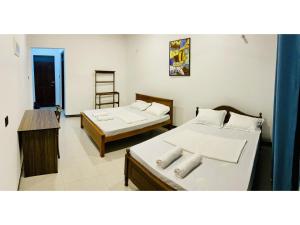 a room with two beds and a desk in it at Victoria Nature Resort in Digana