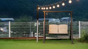 a chair sitting under a gazebo with lights at Gapyeong Ddobagi Pet & Spa Glamping in Gapyeong
