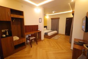 a room with a bedroom with a desk and a bed at Le Eden Premium Wayanad Pool Resort in Sultan Bathery