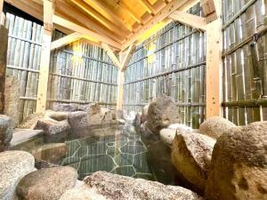 a pool of water in a building with rocks at Iroriyado Hidaya in Takayama +35 photos