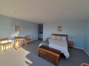 a bedroom with a bed and a table and chairs at Accomodation at Curio in Curio Bay