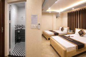 a hotel room with two beds and a bathroom at Thành Trung Motel in Cat Ba