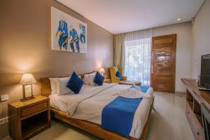 a bedroom with a large bed and a television at Abian Harmony Hotel in Sanur