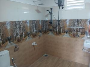 a bathroom with a painting of a forest at Sigiri Arana Sigiriya in Sigiriya +100 photos