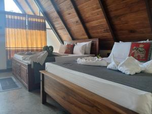 two beds in a room with wooden walls at Sigiri Arana Sigiriya in Sigiriya