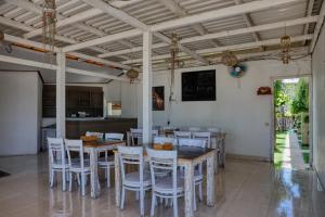 a dining room with tables and chairs and a kitchen at Kelingking Point in Nusa Penida