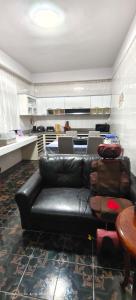 a living room with a black leather couch and a table at AnChanPoolvilla อัญชัญ พลูวิลล่า in Pak Johng