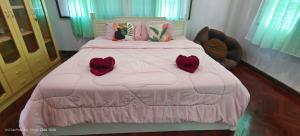 a bedroom with a pink bed with two roses on it at AnChanPoolvilla อัญชัญ พลูวิลล่า in Pak Johng +23 photos