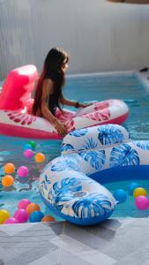 a little girl sitting in the water in a pool at AnChanPoolvilla อัญชัญ พลูวิลล่า in Pak Johng