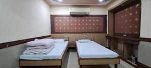 a room with two beds and a wall with a heater at Hotel Shri Shanti Niwas in Bikaner