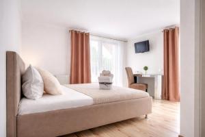 a white bedroom with a bed and a window at Oana's Boutique in Bran