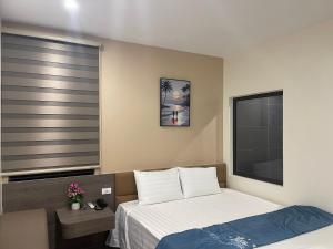 a bedroom with a bed and a large window at Ruby Motel in Trà Phương