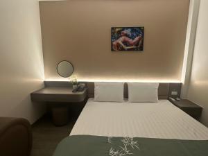 a small bedroom with a bed and a sink at Ruby Motel in Trà Phương