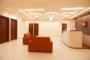 a lobby with two chairs and a reception desk at S V Grand Inn in Bangalore