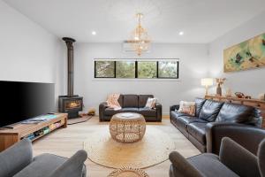 a living room with leather couches and a fireplace at The Cape House in Cape Woolamai