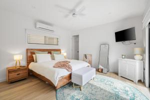 a bedroom with a bed and a tv on the wall at The Cape House in Cape Woolamai
