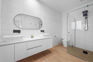 a white bathroom with two sinks and a shower at The Cape House in Cape Woolamai +14 photos