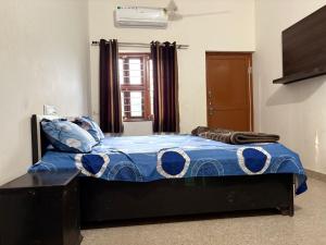 a bed with a blue comforter in a room at Hotel Vishal in Jaipur
