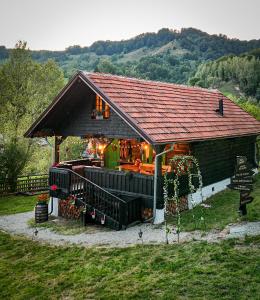 a small house with a roof on a field at La Răscoala in Petrila