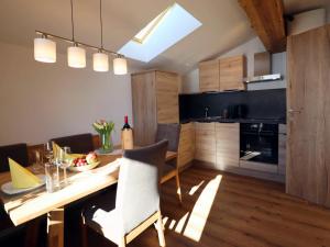 a kitchen and dining room with a table and chairs at Leogang apartment with mountain views in Leogang